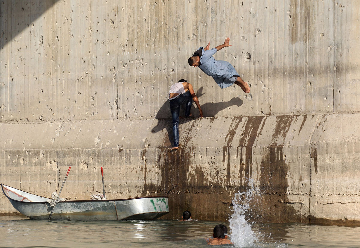 A man jumps in the Euphrates river during hot weather in Raqqa, Syria on 23 May 2018. Photo: Reuters
