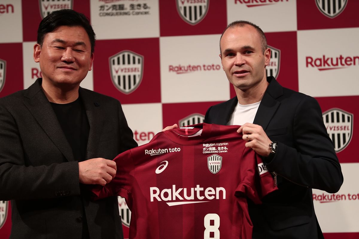 Spanish football star Andres Iniesta (R) and Hiroshi Mikitani, owner of Rakuten and Vissel Kobe club, hold the team`s jersey during a press conference in Tokyo on Thursday. AFP
