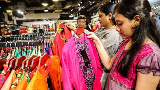 Shoppers of different ages are seen to look for unique cuts, designs and colours in dresses in different shopping complexes. This photo was taken from Bashundhara City Shopping Mall on Thursday. Photo: Prothom Alo