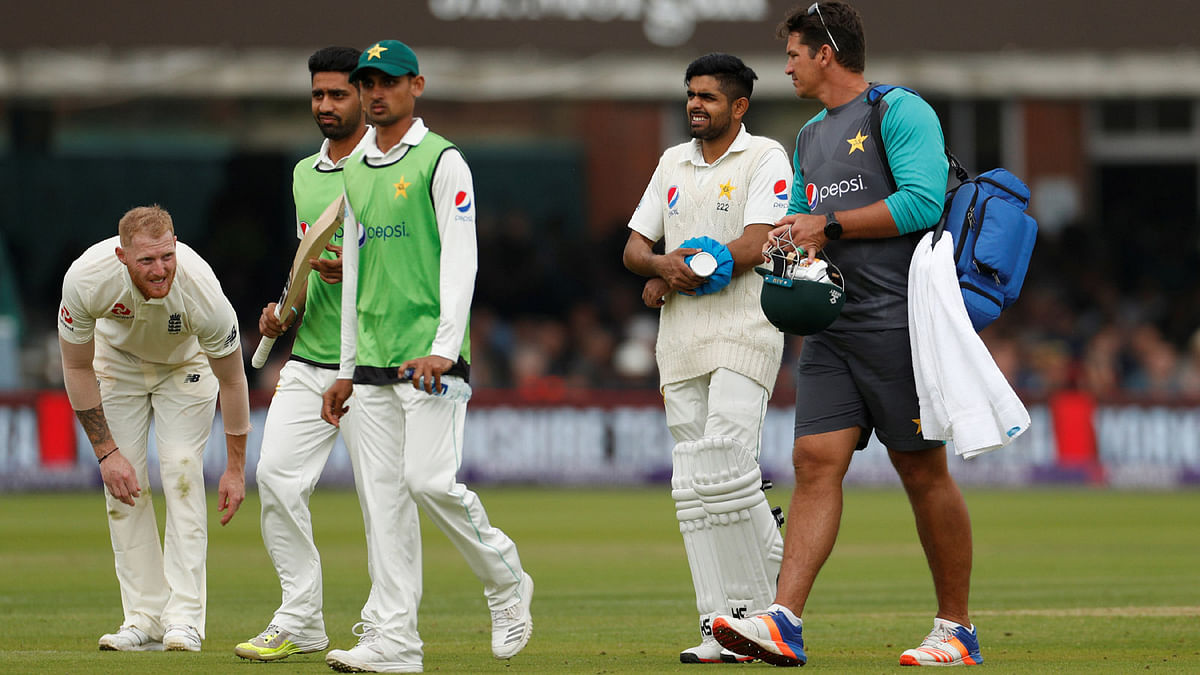 Pakistan batsman Babar Azam receives medical attention after being hit by a ball by England player Ben Stokes before retiring hurt in the First Test match at Lord's Cricket Ground, London, Britain on 25 May 2018. Photo: Reuters