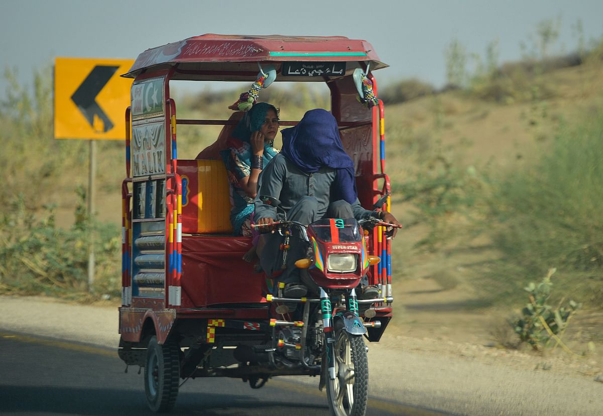 Pakistani people cover their faces as they travel on a hot summer day at Islamkot in Tharparkar district in Sindh province on 22 May 2018. Photo: AFP