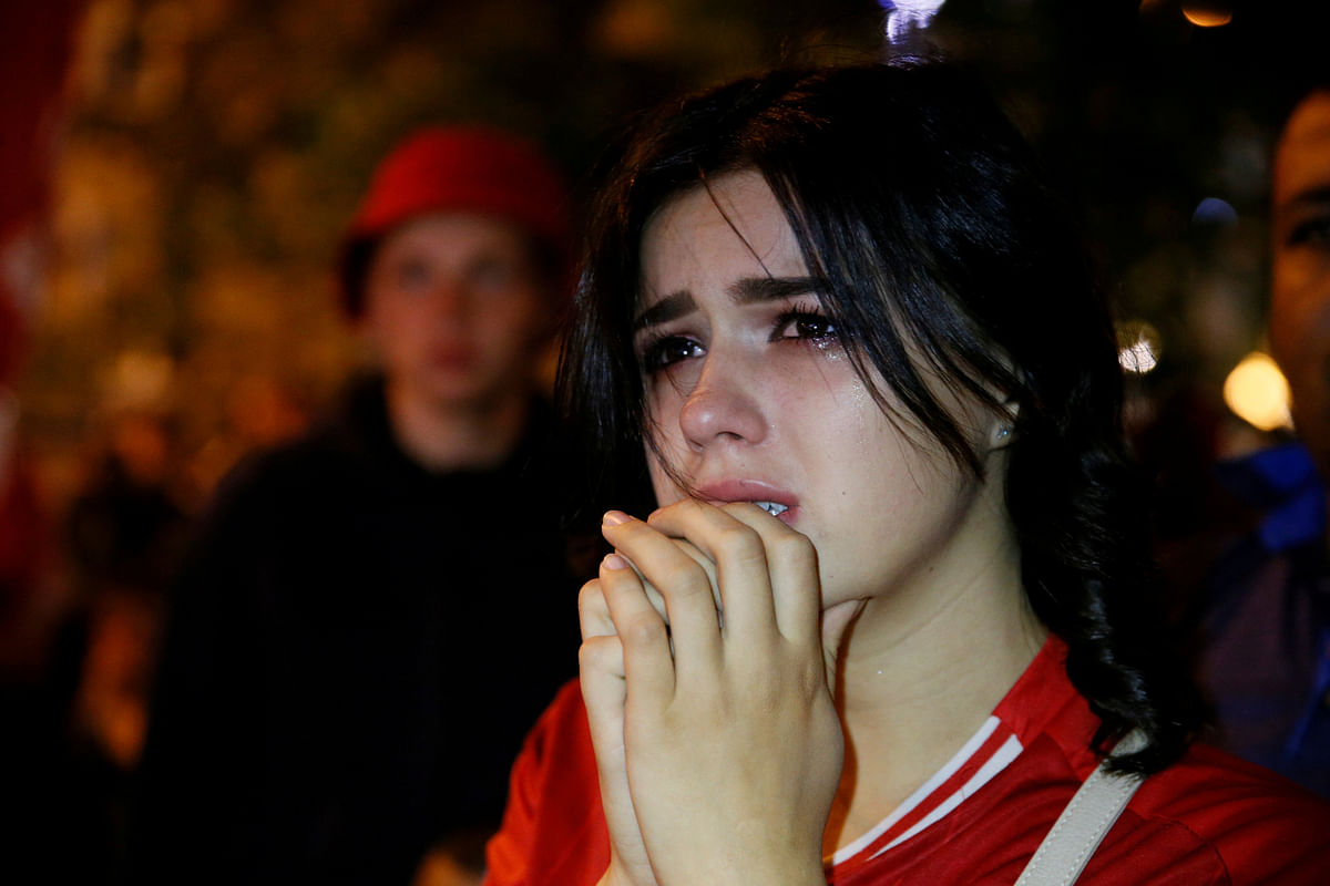Liverpool fan looks dejected after watching the match on a television screen outside the stadium. Photo: Reuters