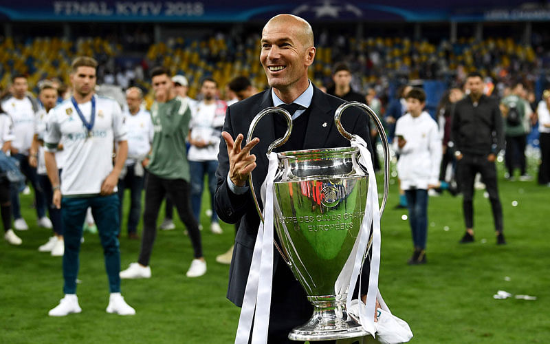 Real Madrid`s French coach Zinedine Zidane gestures the number three and holds the trophy as he celebrates winning the UEFA Champions League final football match between Liverpool and Real Madrid at the Olympic Stadium in Kiev, Ukraine, on 26 May 2018. Photo: AFP