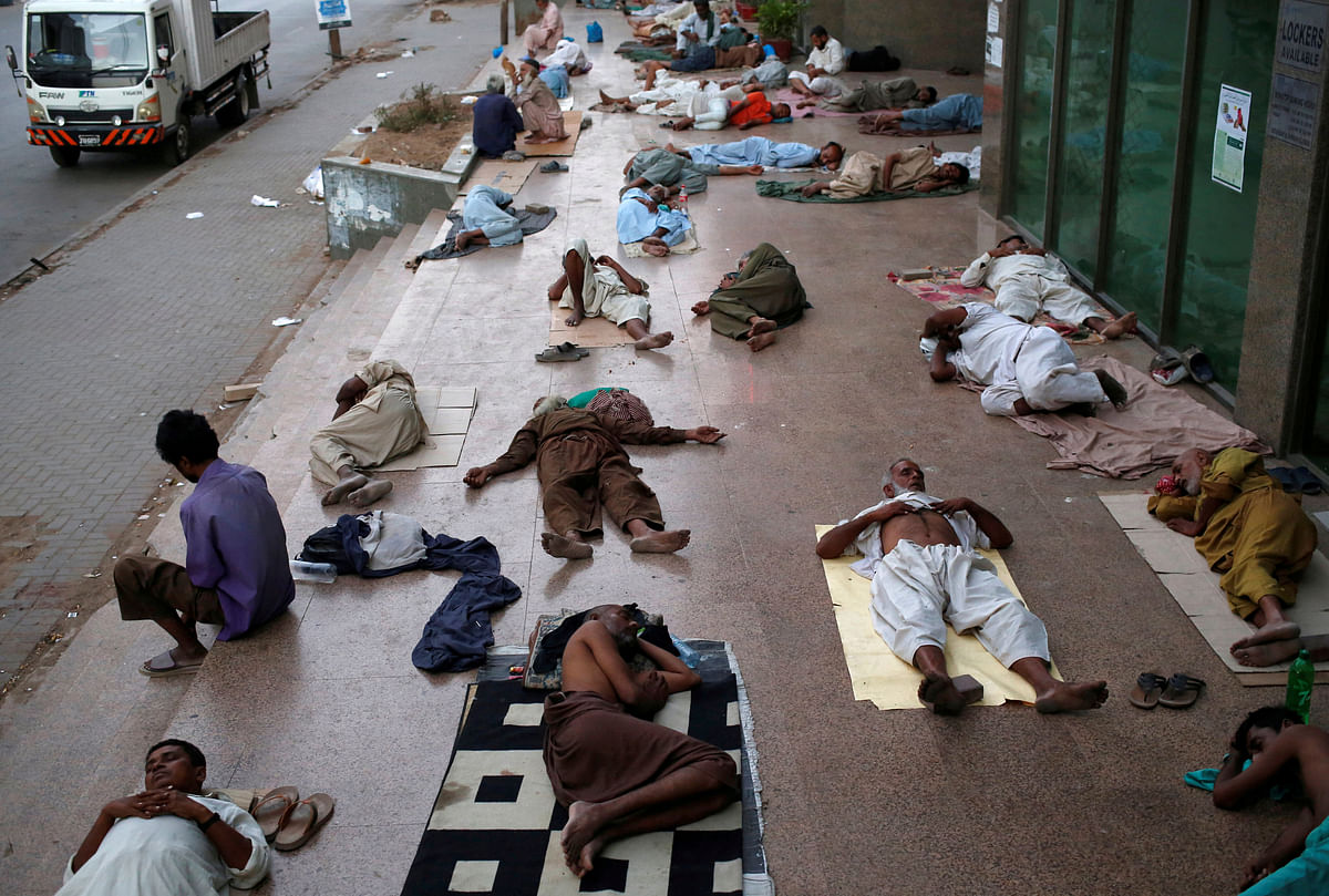 Residents sleep on a building pavement, to escape heat and frequent power outage in their residence area Karachi, Pakistan on 22 May 2018. Photo: Reuters