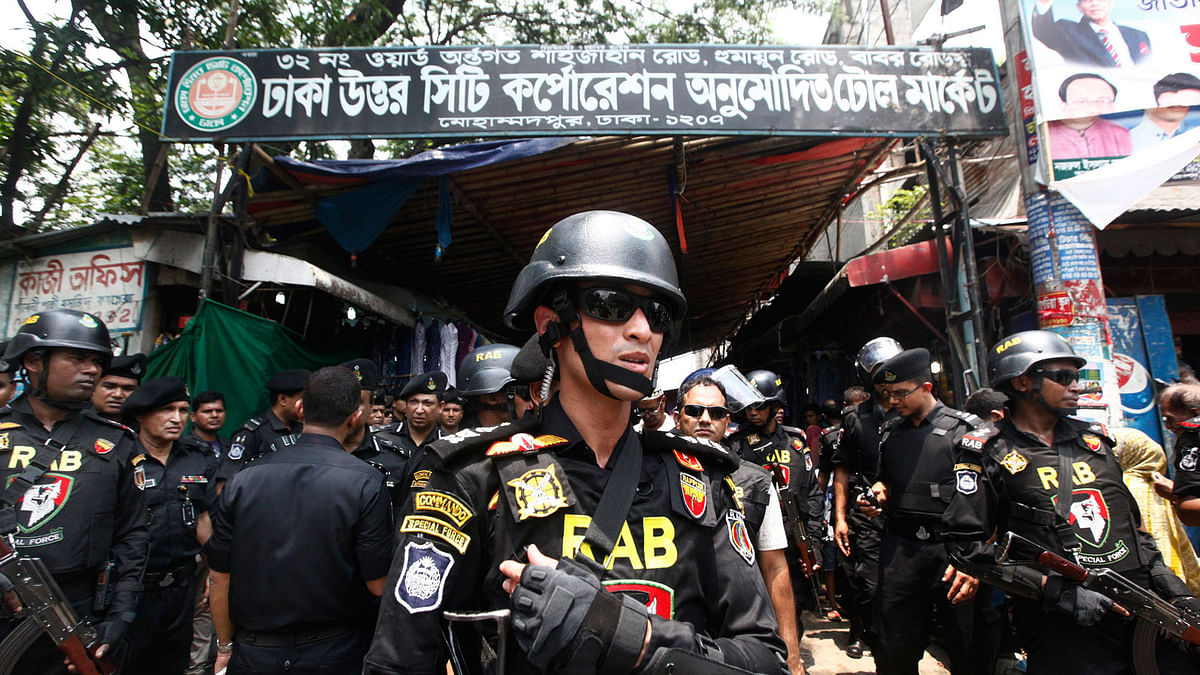 Bangladesh`s Rapid Action Battalion (RAB) soldiers stand guard during a raid on suspected drug dealers at Mohammadpur Geneva Camp in Dhaka, Bangladesh, on 26 May. Photo: AP