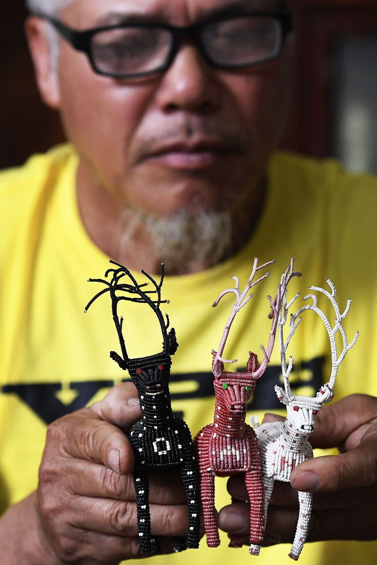 This picture taken on 24 April 2018 shows Nguyen Truong Chinh displaying intricately crafted animals made from plastic bags by his son and death row inmate Nguyen Van Chuong, during an interview with AFP at his home in Hai Duong. Photo: AFP