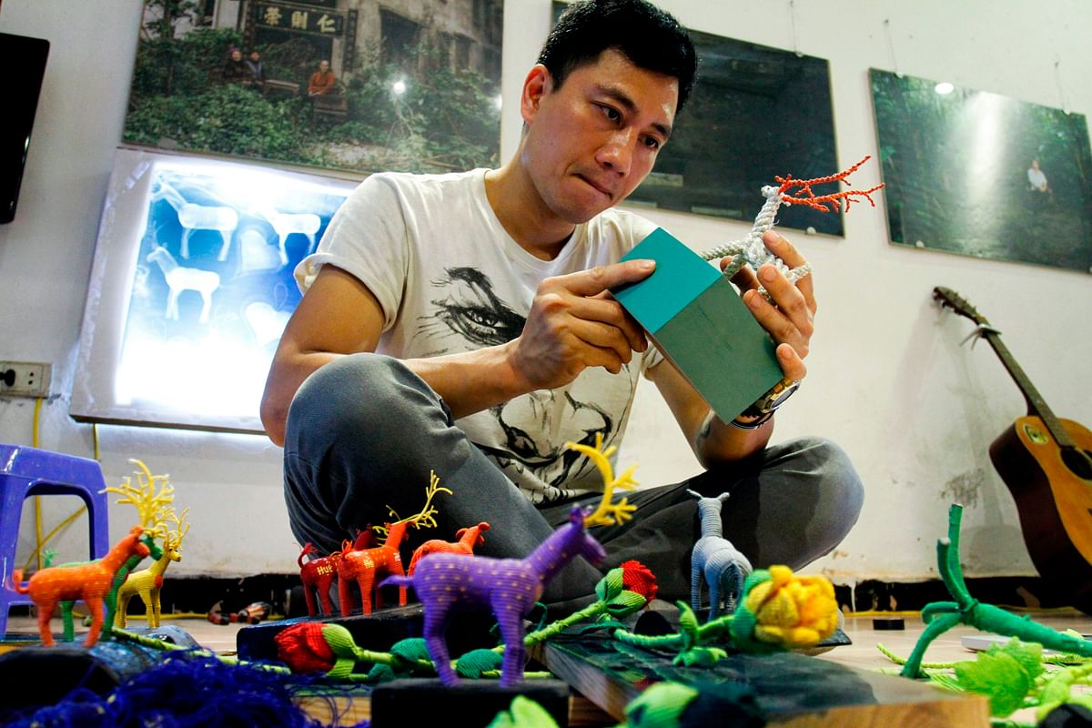 This picture taken on 29 March 2018 shows Vietnamese artist Thinh Nguyen displaying intricately crafted animals and flowers made by inmates on Vietnam`s death row, during an interview with AFP at his studio in Hanoi.