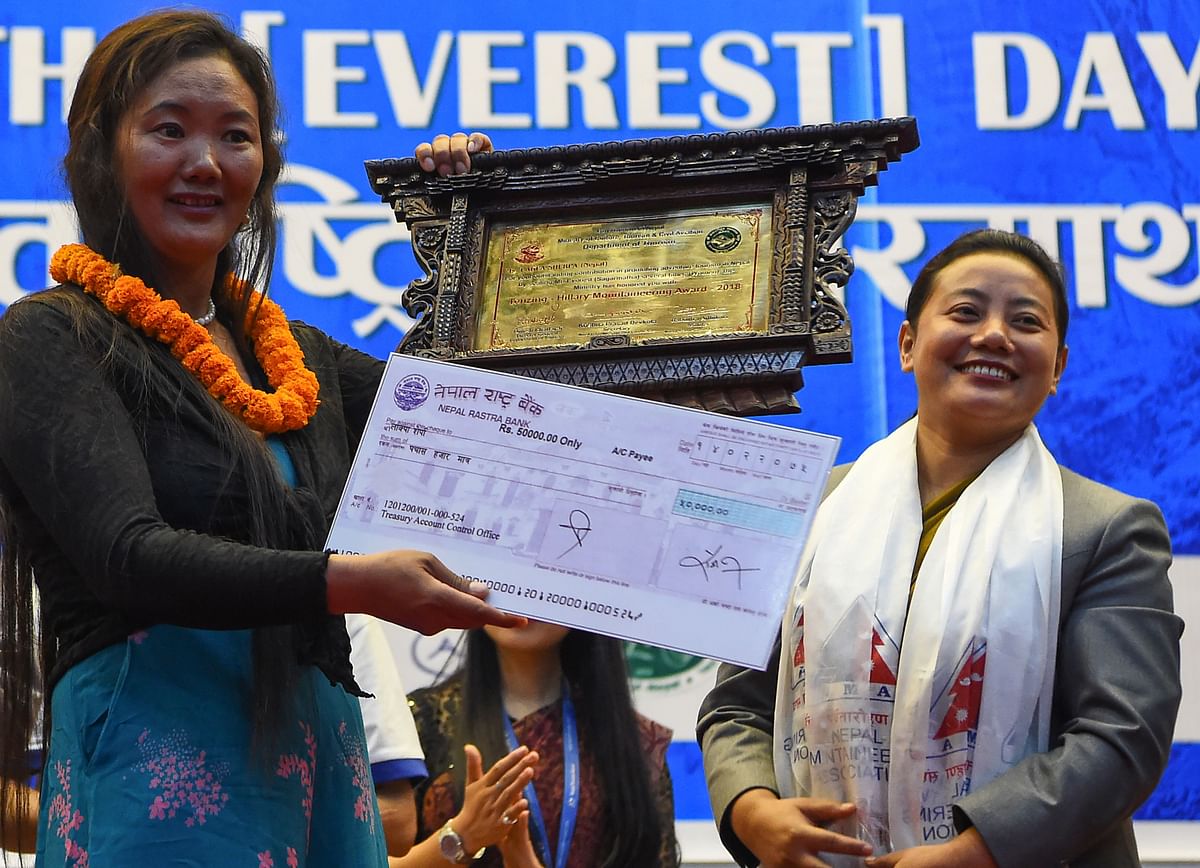 Nepali mountainer Kami Rita Sherpa (L), who has reached the summit of the Everest 22 times, receives Tenzing Hillary Mountaineering Award during the 11th International Everest Day in Kathmandu on 29 May 2018. Photo: AFP