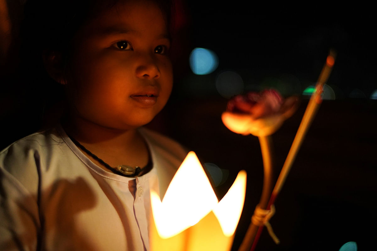 A girl carries a candle as she prays during the Vesak Day, an annual celebration of Buddha`s birth, enlightenment and death, at a temple in Chonburi province, Thailand on 29 May 2018. Photo: Reuters