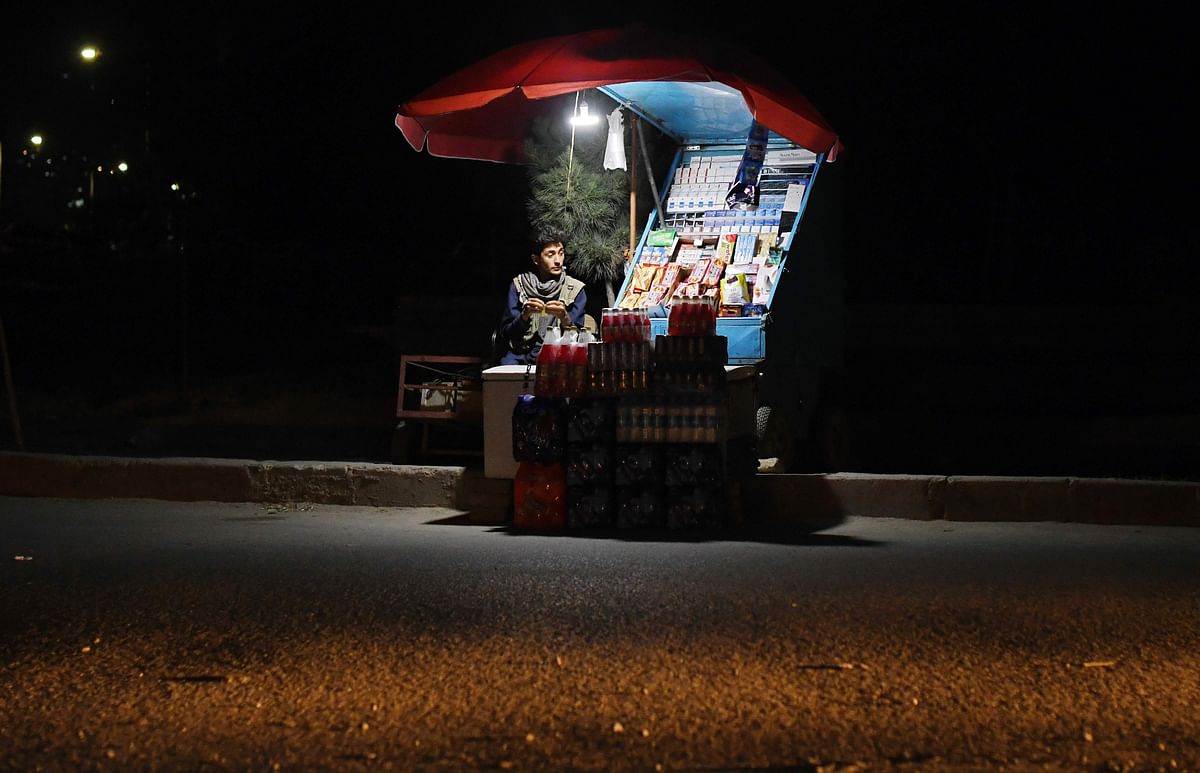 In this photograph taken on 27 May 2018 an Afghan cigarette vendor waits for customers at his stall along the road in Kabul. Photo: AFP