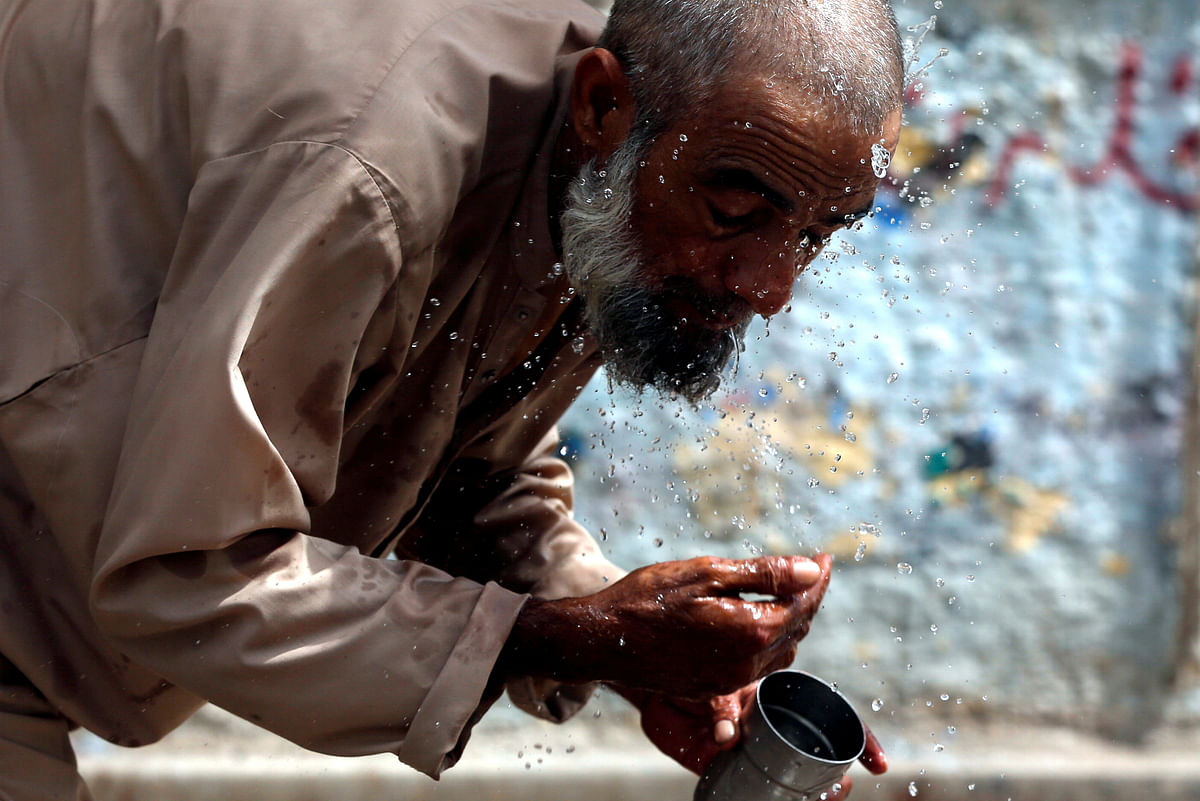 A man splashes his face with water to cool off from the heatwave, along a road in Karachi, Pakistan on 29 May, 2018. Photo: Reuters.
