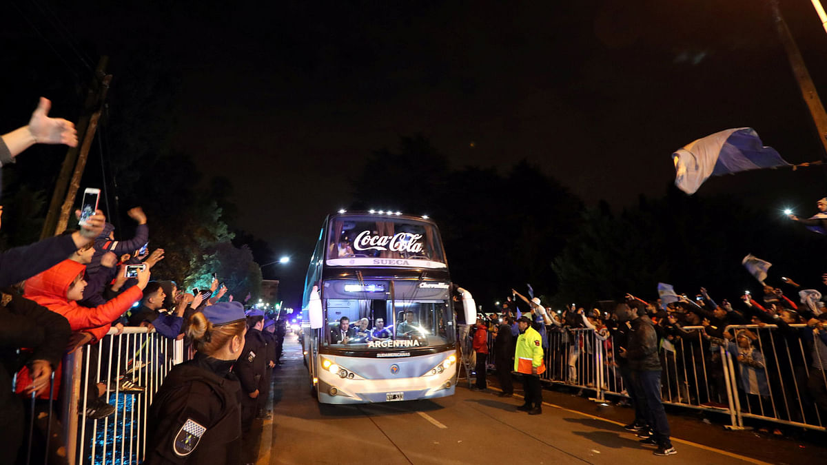 People wave at Argentina`s players as they ride a bus to go to the airport. Photo: Reuters.