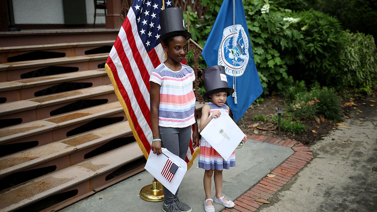aphaela Ekwujuru (L) poses with her sister after taking the Oath of Citizenship during a children`s citizenship ceremony hosted by US Citizenship and Immigration Services on 31 May 2018 in Washington, DC. Photo: AFP
