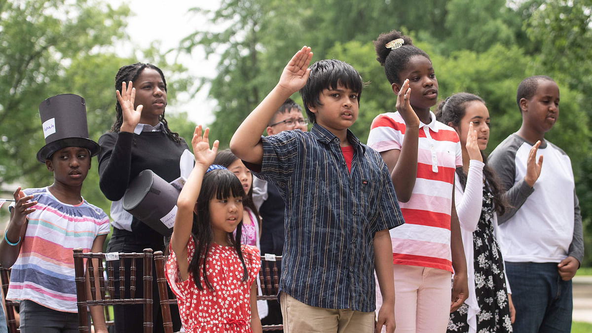Children take the oath of citizenship during a special citizenship ceremony at President Lincoln`s Cottage in Washington, DC, on 31 May 2018. Photo: AFP