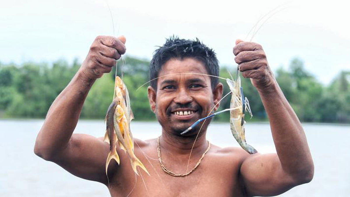A fisherman smiling holding shrimps in hands. Sharafpur, Dumuria, Khulna on 31 May. Photo: Saddam Hossain