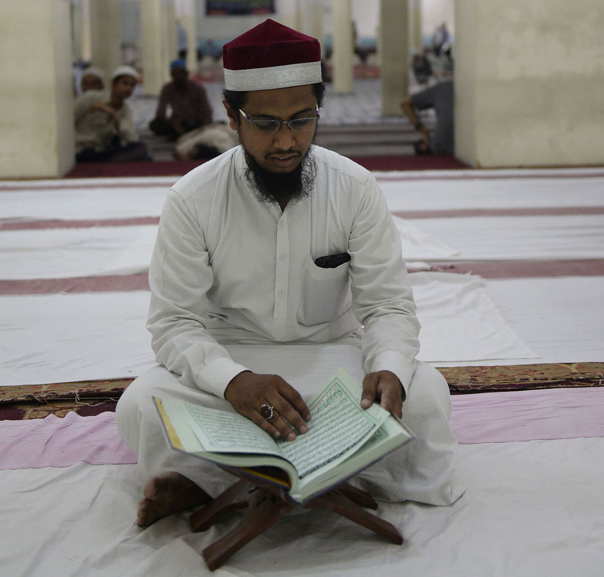 An Indian Muslim devotee reads the Quran prior to breaking his fast during the Holy month of Ramadan at the Jama Masjid in Secunderabad, the twin city of Hyderabad on 1 June 2018. Photo: AFP