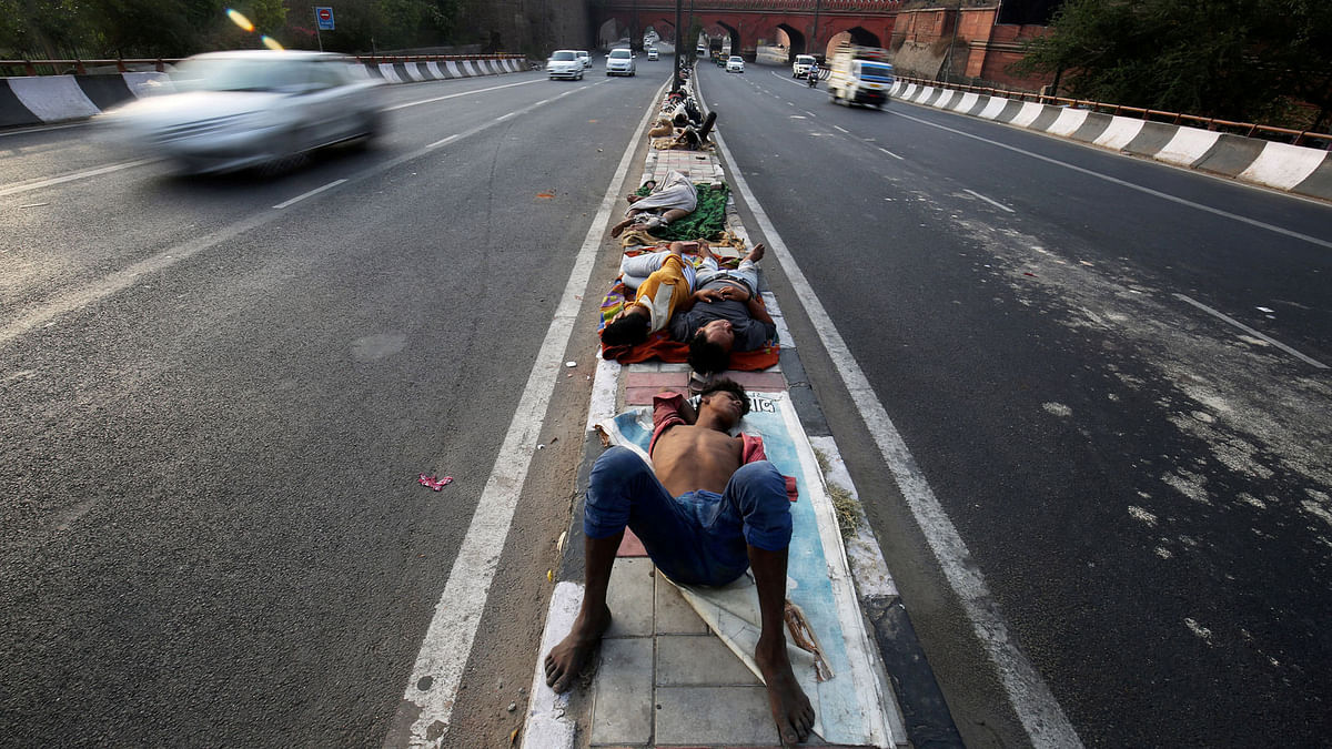 People sleep on a road divider in New Delhi, India on 1 June. Photo: AP