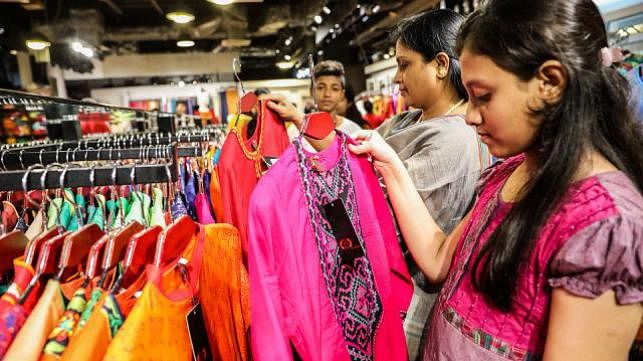 Shoppers of different ages are seen to look for unique cuts, designs and colours in dresses in Bashundhara City on Thursday. Photo: Prothom Alo