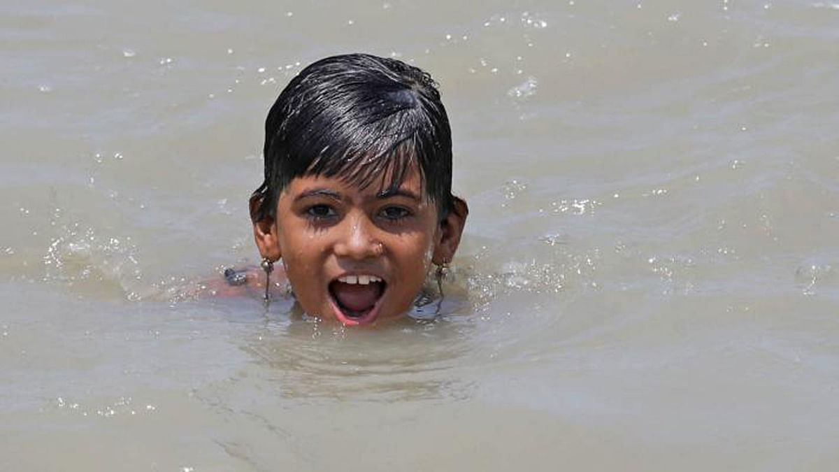 A child baths in the river of Karnaphuli in Fishery Ghat area of Chattogram on 27 May. Photo: Jewel Shil