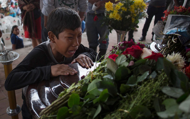 A youth cries over the coffin of Nery Otoniel Gomez Rivas, 17, whose body was pulled from the volcanic ash during the eruption of the Volcan de Fuego, which in Spanish means Volcano of Fire, during his wake at the main park of the town San Juan Alotenango, Guatemala on 4 June. Photo: AP