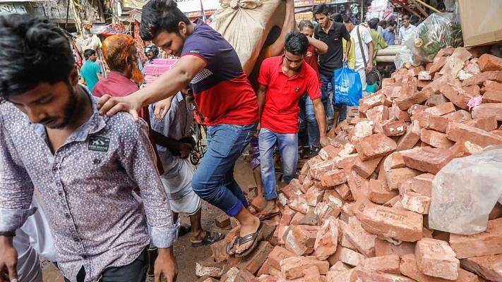 Bricks are piled on road. Pedestrians face difficulty as they pass by. Chawkbazar, Dhaka, 4 June. Photo: Dipu Malakar