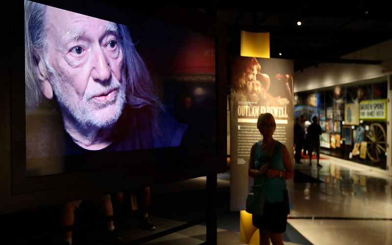 In this 25 May 2018 photo, a video featuring Willie Nelson is played in the Outlaws & Armadillos exhibit at the Country Music Hall of Fame and Museum in Nashville, Tennessee. Photo: AP