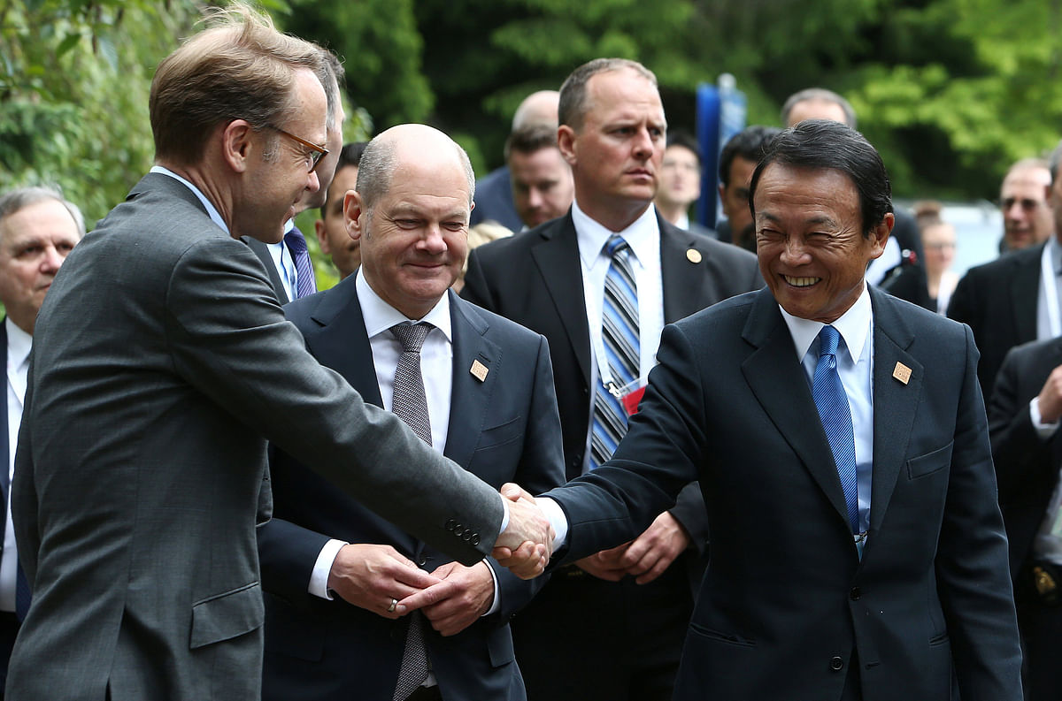 President of the German Federal Bank Jens Weidmann shakes hands with Japan`s minister of finance Taro Aso near Germany`s minister of finance Olaf Scholz while arriving at the welcome reception dinner during the G7 Finance Ministers Summit in Whistler, British Columbia, Canada, 31 May 2018. Photo: Reuters