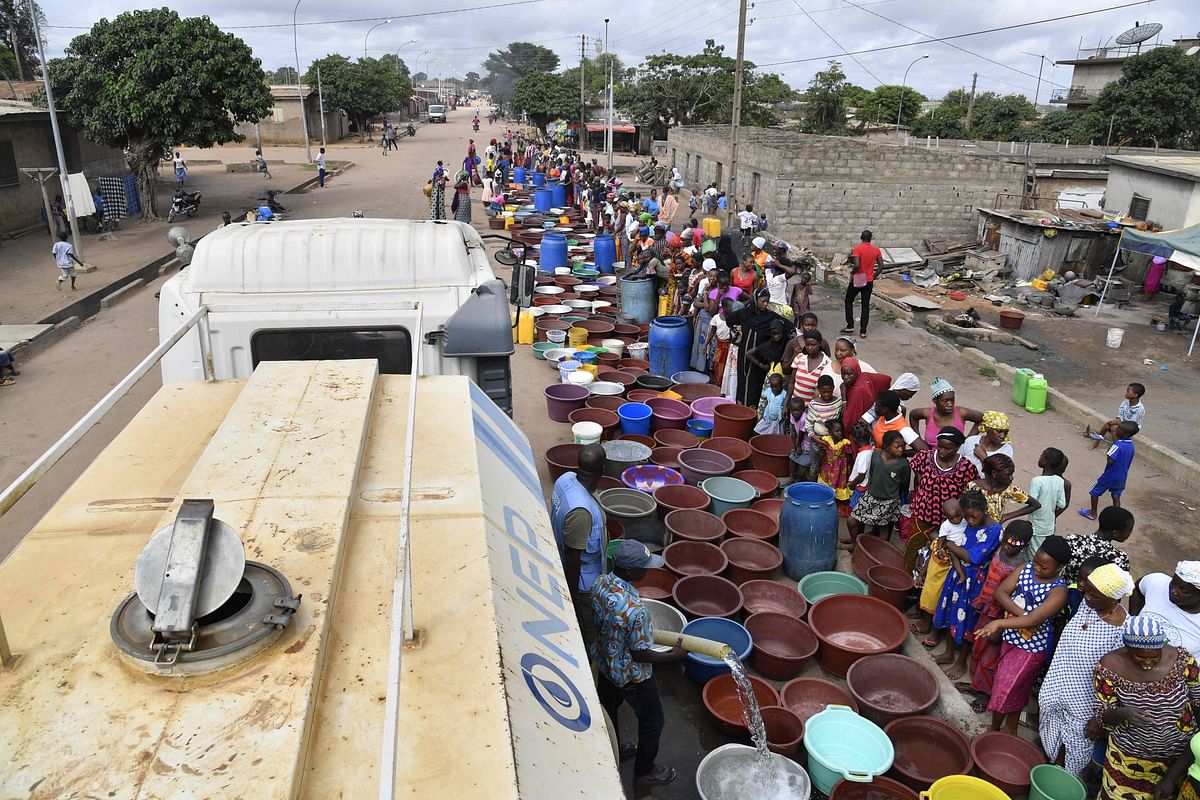 Agents of the National Office of Drinking Water (ONEP) distribute water to the population on 2 June 2018 in a district of Bouake, central Ivory Coast, where the largest dam of the `Societe de Distribution de l`Eau de la Cote d`Ivoire` (SODECI - Water Distribution Company of Ivory Coast) has dried for several weeks. Photo: AFP