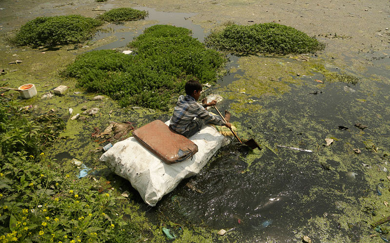 A young boy collects plastic and other recyclable material from the polluted waters of Babdemb lake on World Environment Day in Srinagar, Indian controlled Kashmir on 5 June. `Plastic pollution is a huge issue everywhere,` UN Environment chief Erik Solheim told The Associated Press in an interview. Photo: AP