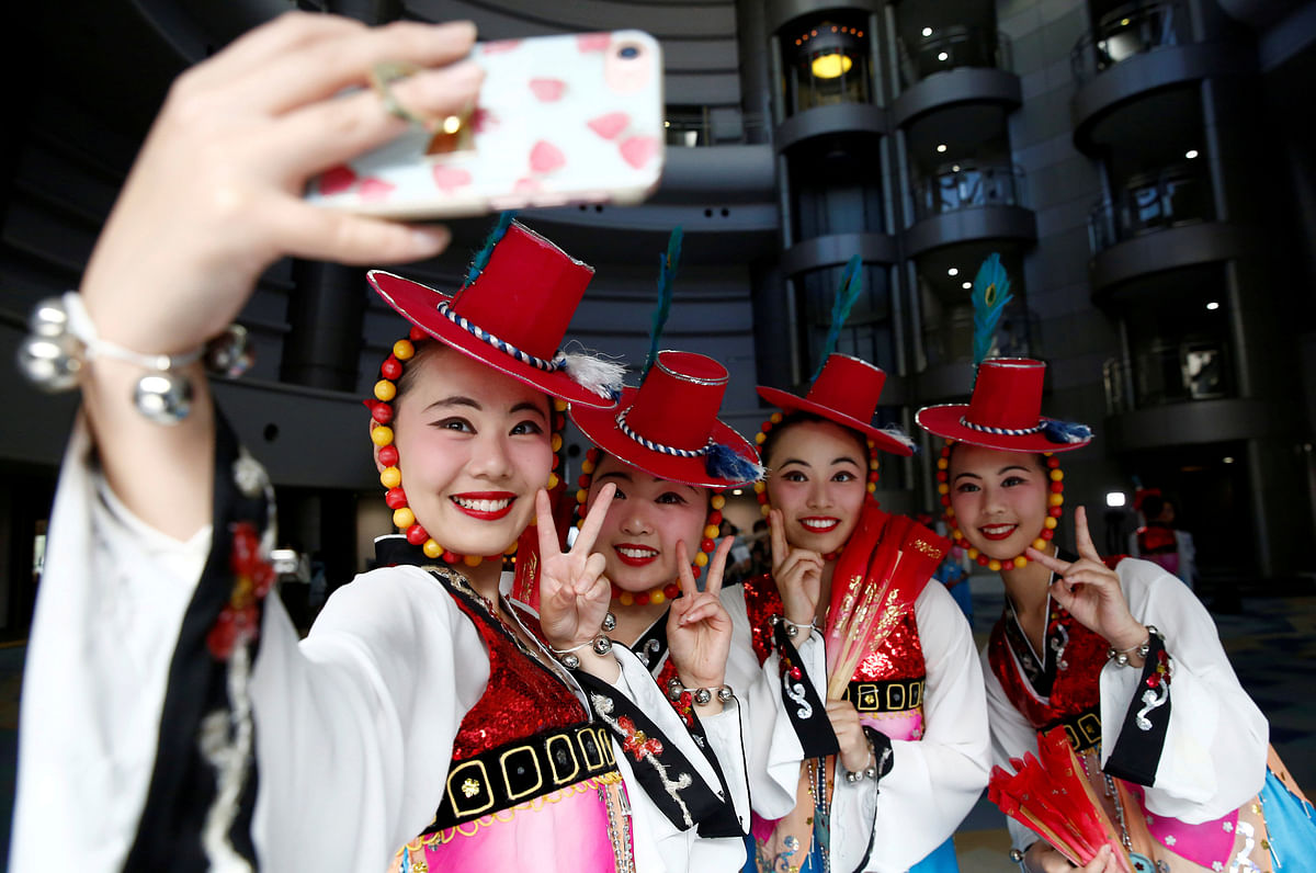 High school students from a dance club at Kanagawa Korean Middle and High School take a selfie after their traditional dance performance at a local international day event to promote a multicultural society in Yokohama, Kanagawa Prefecture, Japan on 20 May 2018. Photo: Reuters