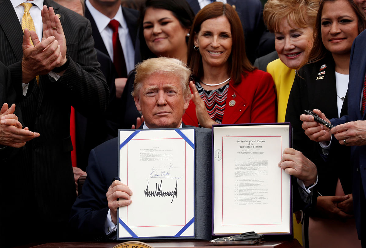 US president Donald Trump displays the `VA (Veterans Affairs) Mission Act of 2018` after signing it in the Rose Garden of the White House in Washington, US on 6 June 2018. Photo: Reuters