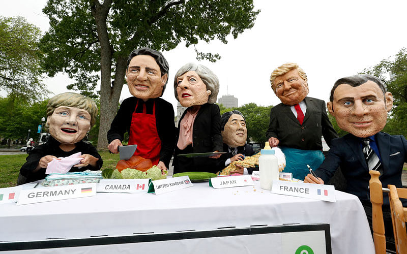 Activists, wearing mask and performing as the leaders of the G7 nations, protest outside the Regional Parliament building during the G7 Summit in Quebec City. Photo: Reuters