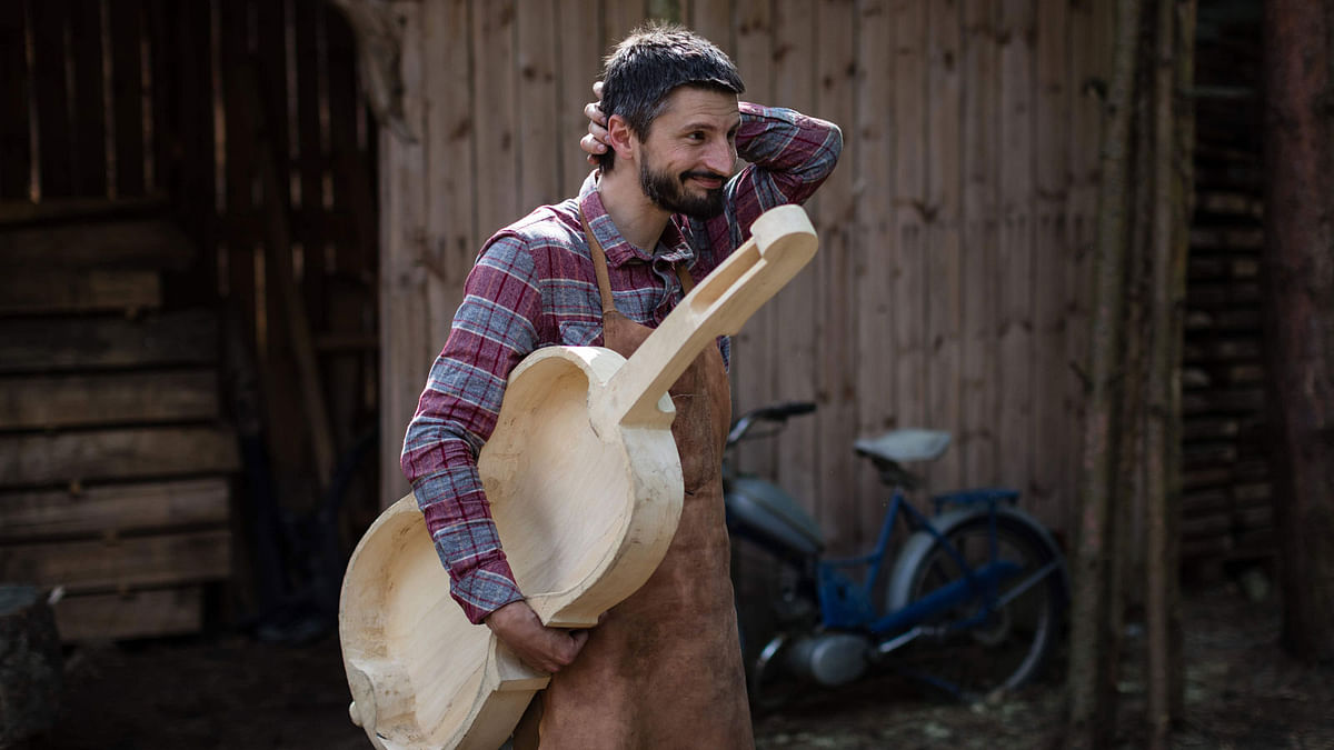 Polish musician and instrument-maker Mateusz Raszewski poses with a kalisz bass that he is building on 10 May 2018 at his workshop in the village of Kamiensko, just north of the western Polish city of Poznan. Photo: AFP