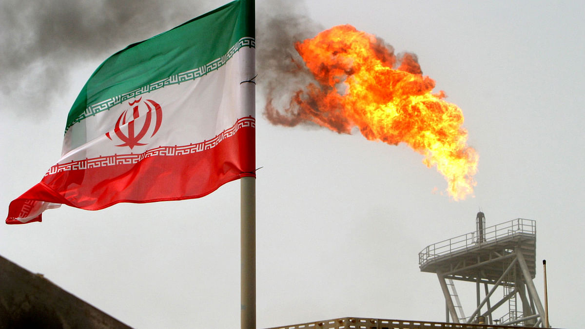 A gas flare on an oil production platform in the Soroush oil fields is seen alongside an Iranian flag in the Persian Gulf, Iran, on 25 July 2005. Reuters File Photo