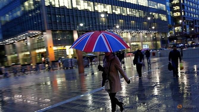 Workers walk in the rain at the Canary Wharf business district in London, Britain on 11 November 2013. Reuters File Photo