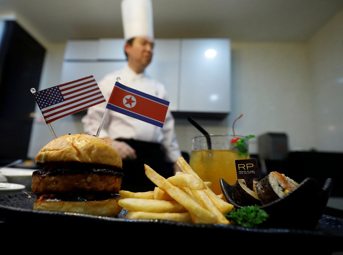 Chef Abraham Tan of Royal Plaza on Scotts` Carousel restaurant stands next to his creation, the Trump Kim burger, in Singapore on 7 June 2018. Photo: Reuters