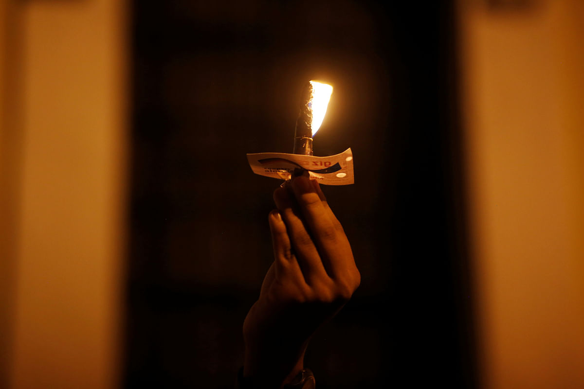 A demonstrator holds a candle during a protest against the Guatemalan government`s disaster agency, which failed to heed advance warnings on Sunday`s eruption of the Fuego volcano, in Guatemala City, Guatemala on 9 June. Photo: Reuters