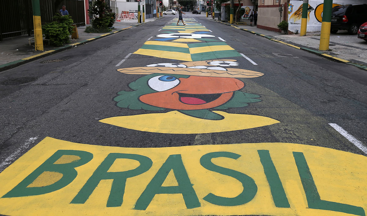 A man walks on a street painted in the colors of the Brazilian flag ahead of the 2018 World Cup, at Vila Isabel neighborhood in Rio de Janeiro. Photo: Reuters