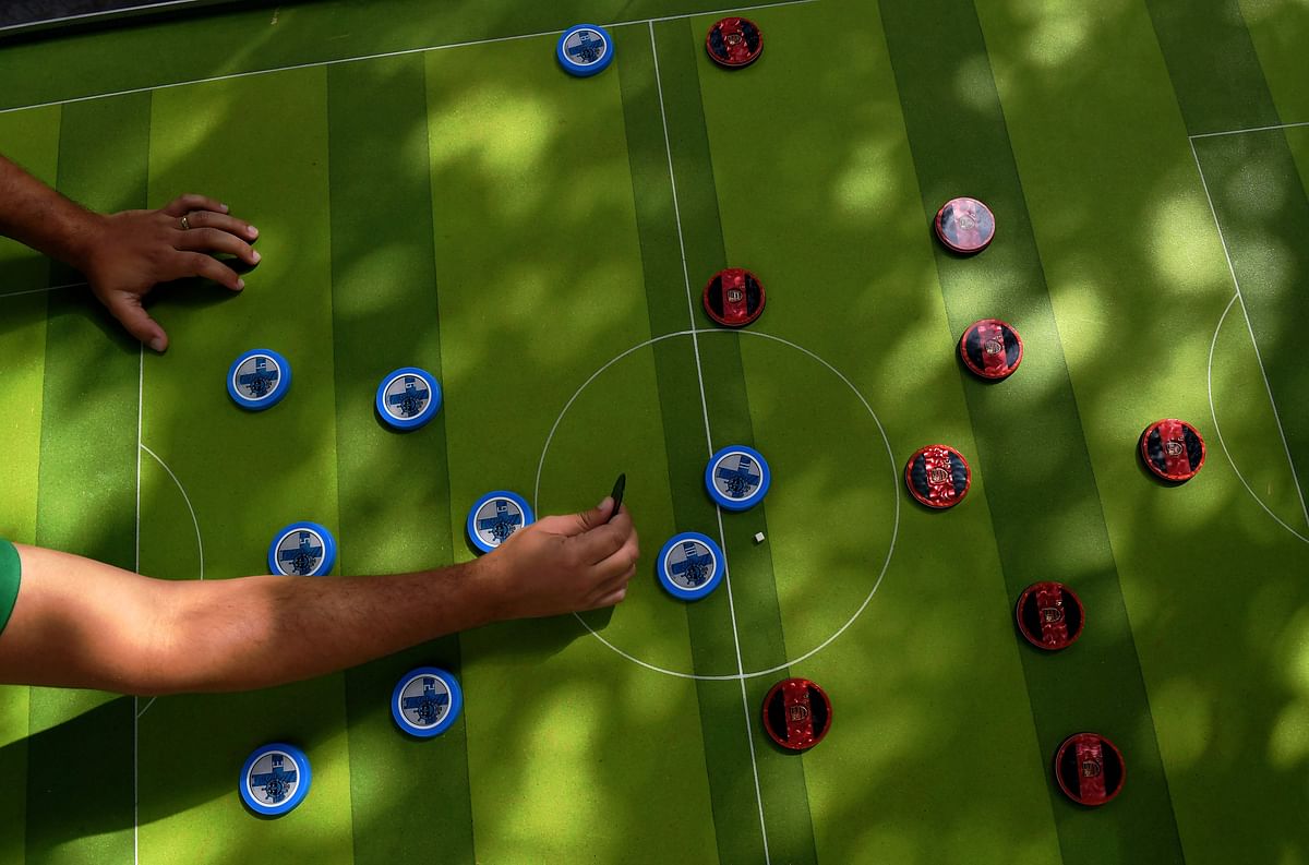 A man plays Button Football in Rio de Janeiro, Brazil on May 19, 2018. Every weekend, some 20 to 30 players meet in Rio de Janeiro to play with their customised colourful buttons, inspired in teams around the world and in legendary players. AFP