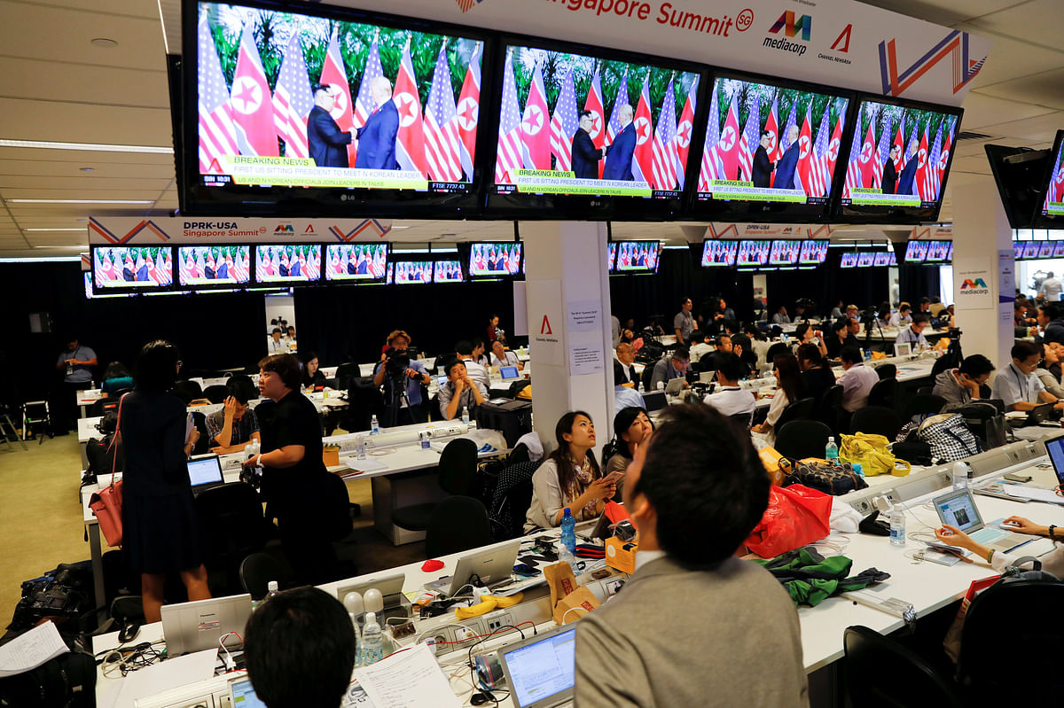A TV screen shows a news report about the meeting between US president Donald Trump and North Korea’s leader Kim Jong Un at a media center for the summit, in Singapore on 12 June. Photo: Reuters
