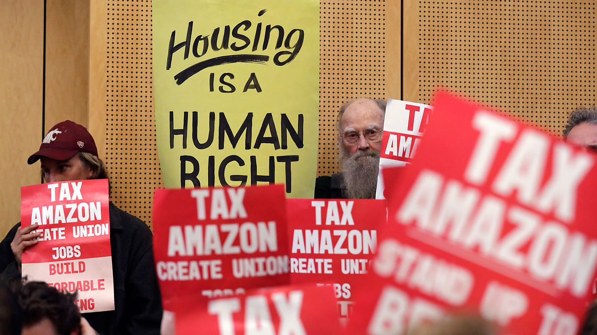 In this 14 May, 2018 file photo, members of the public look on at a Seattle City Council before the council voted to approve a tax on large businesses such as Amazon and Starbucks to fight homelessness in Seattle. Photo : AP