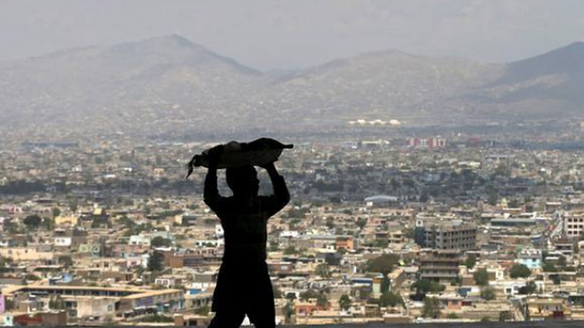 A boy carries bread on his head to sell on a hilltop overlooking Kabul on 20 April 2015. -- A Reuters file photo