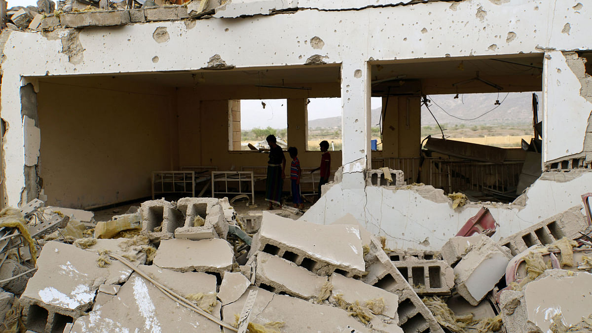 Boys stand inside a Doctors Without Borders medical facility after it was hit by an air strike in Abss, Yemen on 11 June 2018. Photo: Reuters