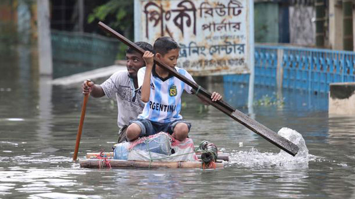 Two young boys enjoy their time on a raft made of bamboo sticks in Agrabad area in Chattogram on 11 June. Photo: Jewel Shil
