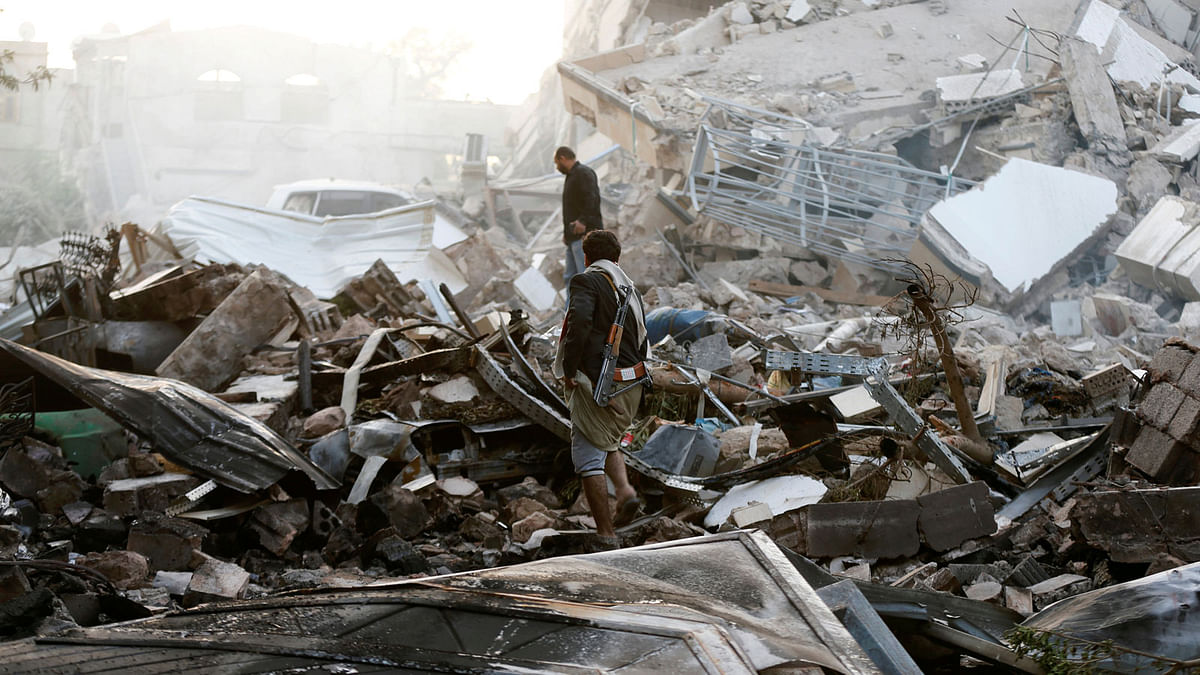 Guards walk on the wreckage of a building destroyed by air strikes in Sanaa, Yemen on 6 June 2018. Photo: Reuters