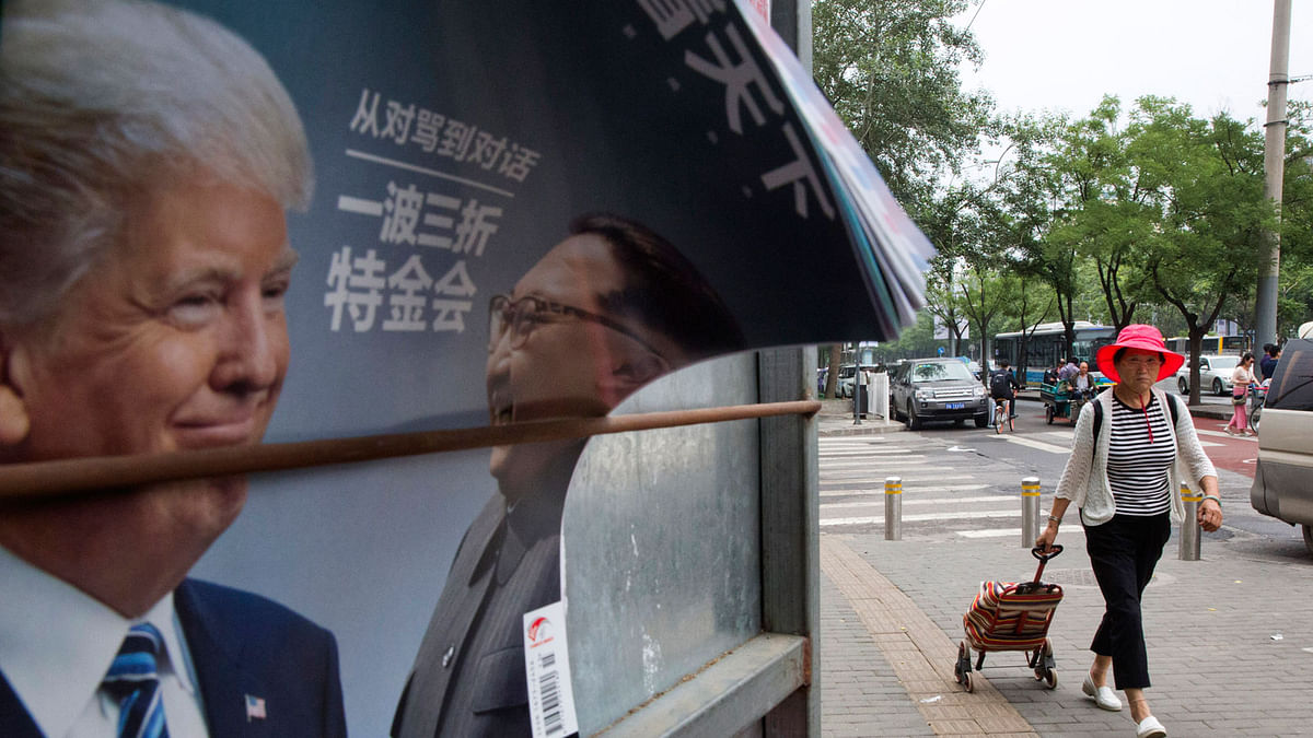 A Chinese woman pulls a trolley bag past a Chinese magazine cover showing US president Donald Trump and North Korean leader Kim Jong Un at a newsstand in Beijing, China, Wednesday, 13 June, 2018. The outcome of the Singapore summit between president Donald Trump and North Korean leader Kim Jong Un was good news for one absent but key player: China