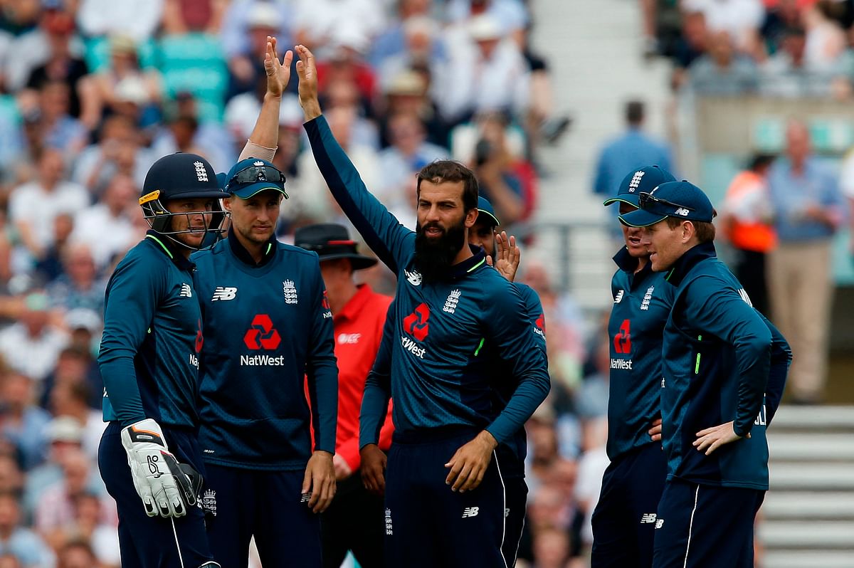 England`s Moeen Ali celebrates with team mates after taking the wicket of Australia`s Shaun Marsh for 24 runs during the first One Day International (ODI) cricket match against Australia at The Oval cricket ground on 13 June. Photo: AFP.