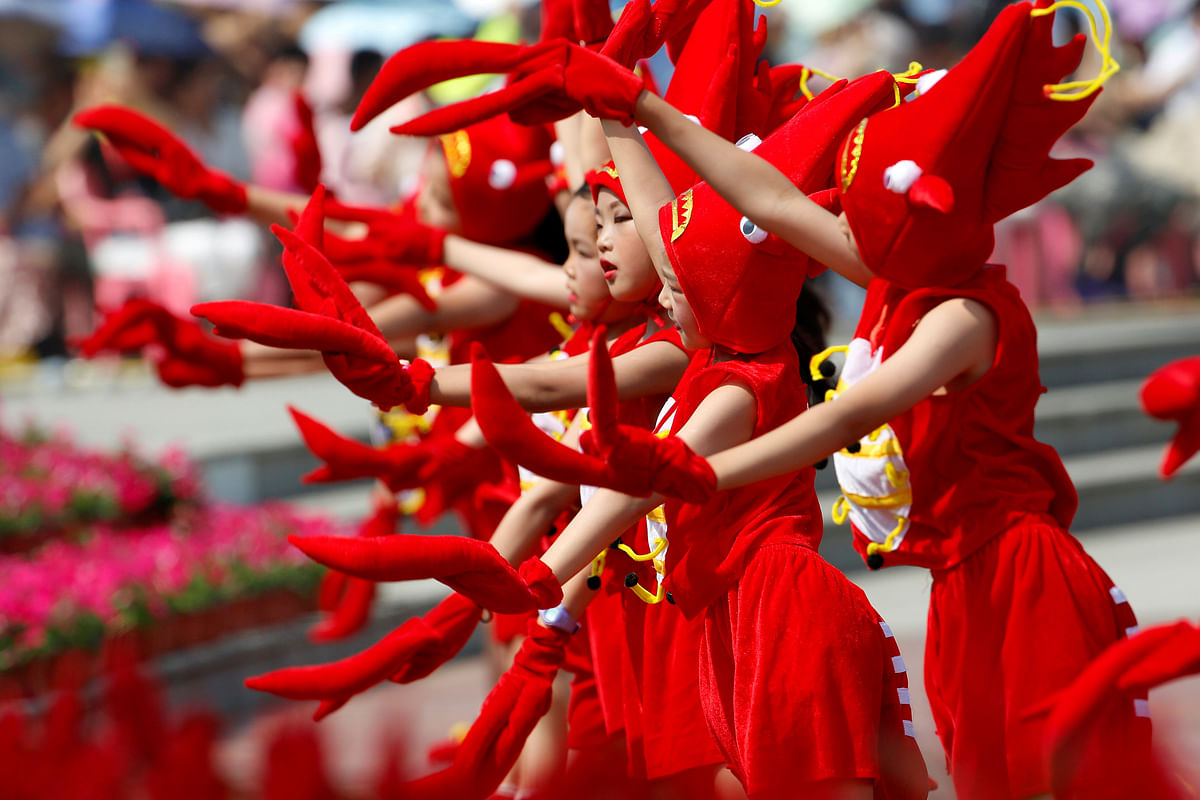 Children dressed in crayfish costumes perform during the opening ceremony of a crayfish festival in Xuyi, Jiangsu province, China 12 June. Photo: Reuters