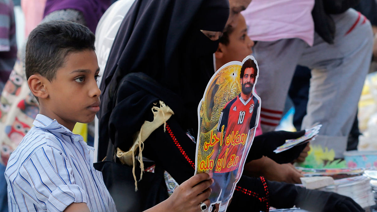 In this 16 May 2018 file photo, a boy buys a Ramadan decoration depicting the Egyptian Liverpool soccer player Mohamed Salah in Sayyeda Zeinab market in preparation for the holy month of Ramadan, in Cairo, Egypt. Photo: AP