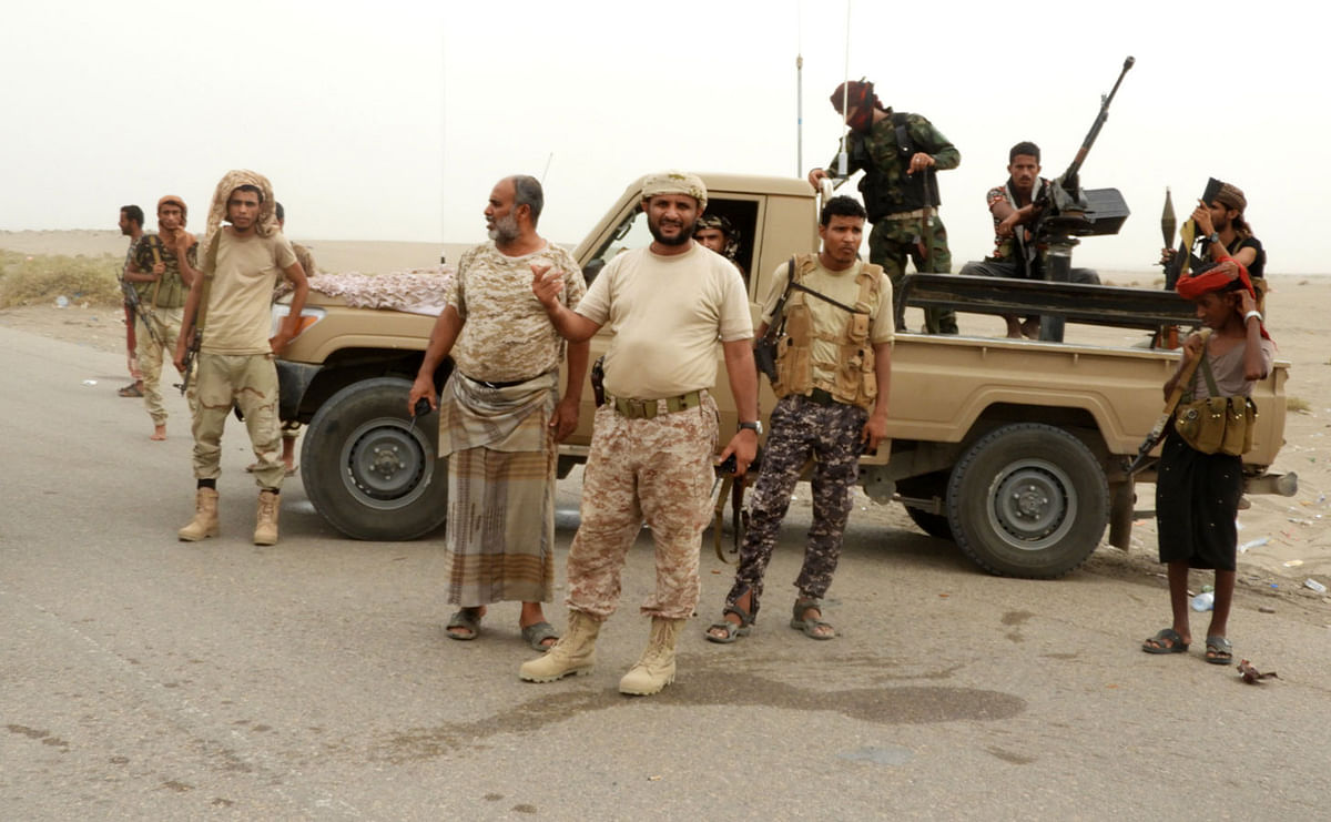 Yemeni pro-government forces stand next to a pickup truck carrying anti-aircraft guns along they way to al-Durayhimi district, about nine kilometres south of Hodeidah international airport on 13 June 2018. Photo: AFP